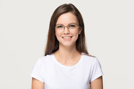Happy teen girl student in glasses isolated on grey background