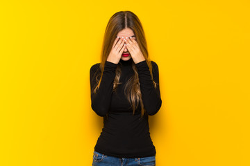 Young pretty woman over yellow background with tired and sick expression