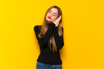 Young pretty woman over yellow background making sleep gesture in dorable expression