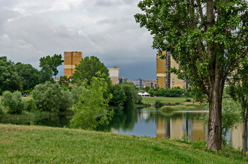 Obraz premium Spring panorama of a part of residential district neighborhood along a lake with green trees, shrubs and flowers, Drujba, Sofia, Bulgaria
