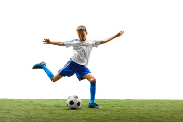 Young boy with soccer ball running and jumping isolated on white studio background. Junior football soccer player in motion