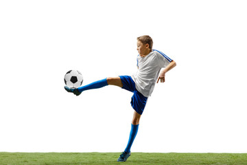 Young boy with soccer ball running and jumping isolated on white studio background. Junior football...