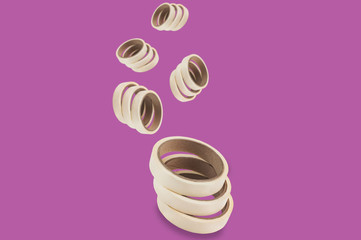 Falling rolls of adhesive paper tape on purple background