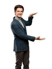 Teenager man with turtleneck holding copyspace to insert an ad over isolated white background