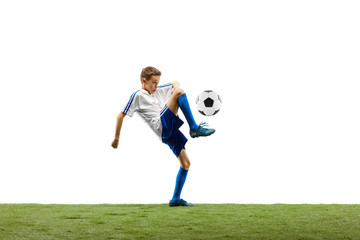 Young boy with soccer ball running and jumping isolated on white studio background. Junior football soccer player in motion