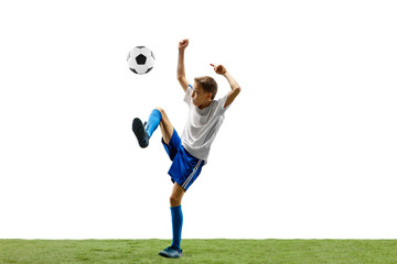 Young boy with soccer ball running and jumping isolated on white studio background. Junior football soccer player in motion