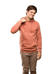 Teenager man with sweatshirt with tired and sick expression over isolated white background