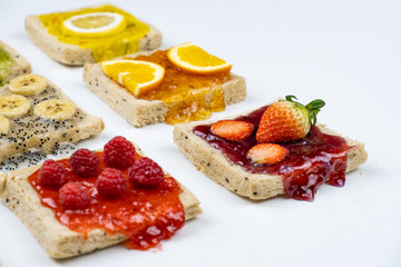 Delicious colourful minimal mix fruits jam on sliced bread. Set on white background.