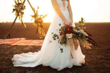Amazing bride in sunset light. Pretty bride. Boho style. Bride wearing fashion wedding dress with...