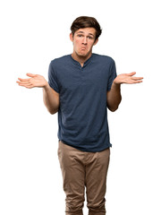 Fototapeta premium Teenager man having doubts while raising hands over isolated white background
