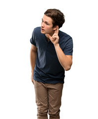 Teenager man listening to something by putting hand on the ear over isolated white background