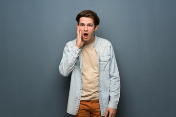 Fototapeta premium Teenager man with jean jacket over grey wall with surprise and shocked facial expression