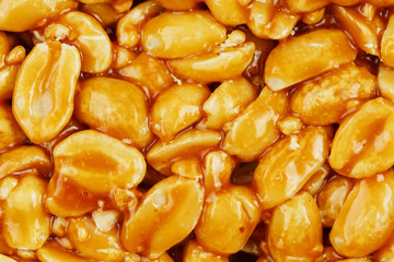 Kozinaki from golden, roasted peanuts beans as a background, texture. Macro shooting, close-up. Place for text