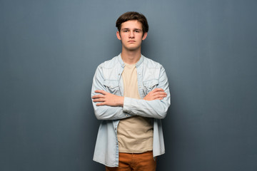 Teenager man with jean jacket over grey wall portrait