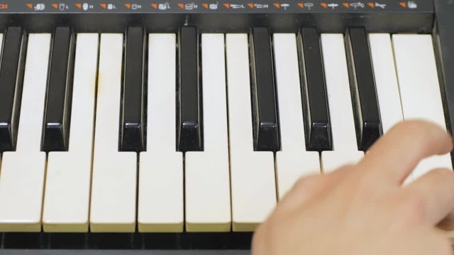 Close up of male play on synthesizer 