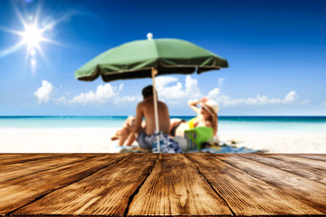 Desk of free space for your product. Beach landscape with people on towel. Ocean water and sun light