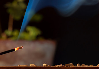 dying incense stick on a dark background