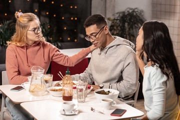 Adorable girls trying to comfort guy by making photos with him.
