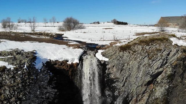 Survol en recul d'une cascade dans un d&eacute;cor d'hiver
