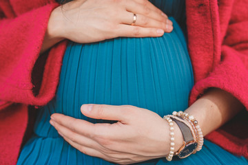 Pregnancy. Pregnant girl. Hands on the belly of a pregnant woman. A heart