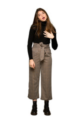 Full-length shot of Pretty girl surprised and shocked while looking right on isolated white background