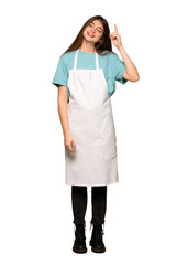 Full-length shot of Girl with apron intending to realizes the solution while lifting a finger up on isolated white background