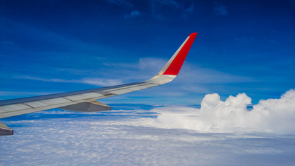 Fototapeta na wymiar Wing of an airplane flying above clouds
