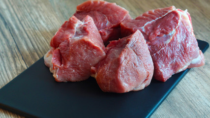 Meat dishes are prepared in the restaurant by the chef. Organic meat from the farm. Cooking for lunch the fresh diet of red meat for gourmets. Red meat on a black Board . Billets for barbecue or kebab