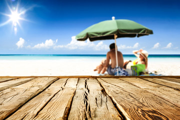 Desk of free space for your product. Beach landscape with people on towel. Ocean water and sun light