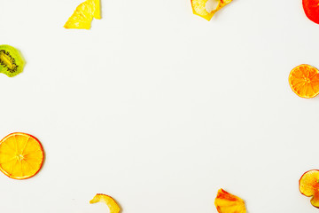 Organic mix of fruit chips on white background. Dried fruits - apple, banana, citrus. Healthy sweet snack. Dehydrated and raw food. Creative summer food comcept. Copy space, top view