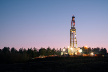 Oil gas drilling rig on sunset background. Industrial concept