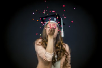 Confetti girl with graduation hat and black background