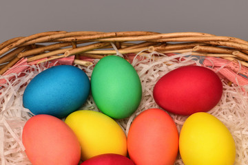 Top view of Easter eggs in basket on grey background. Horizontal photography