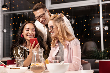 Couple with common female friend watching photos of their wedding and melting.