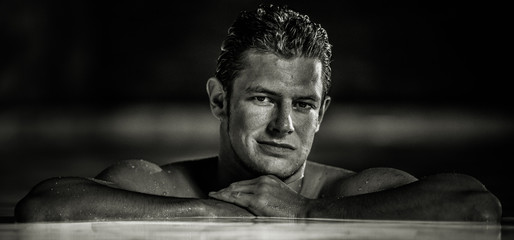 Fototapeta na wymiar Portrait of caucasian male model in smimming pool by night