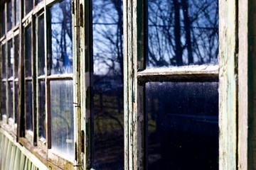 Dilapidated rotten windows on derelict building awaiting demolition with shallow depth of field