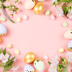 Fototapeta na wymiar Festive Happy Easter background with decorated eggs, flowers, candy and ribbons in pastel colors on pink. Copy space
