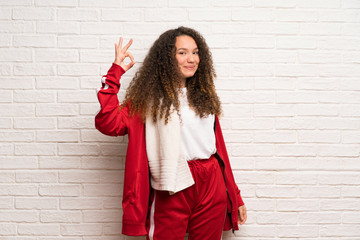 Teenager sport girl with curly hair showing ok sign with fingers