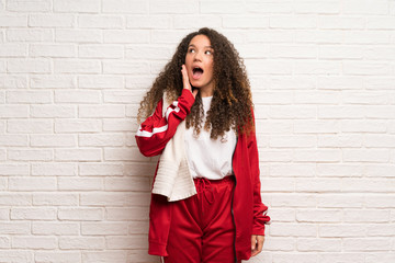 Teenager sport girl with curly hair with surprise and shocked facial expression