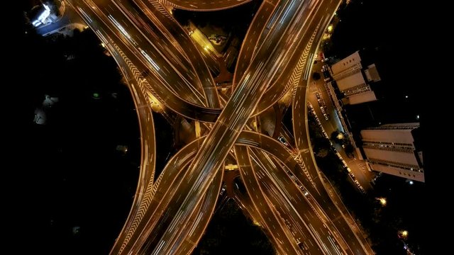 Spinning night highway drone timelapse. Time lapse looking down at freeway interchange in downtown Shanghai, China. Modern metropolis busy roads at rush hour in downtown city center.