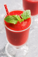 Close-up healthy vegan strawberry smoothie in glasses on a gray background. Summer strawberry smoothie. Selective focus