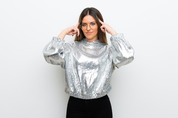 Young woman with glasses over white wall having doubts and thinking