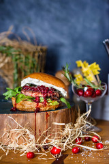 Delicious burger with beef, cheese and cranberry sauce on wooden counter.