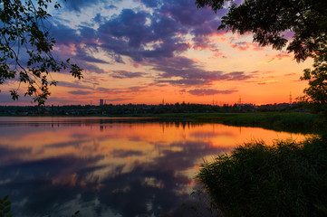 Fototapeta na wymiar Awesome summer sunset landscape in Krivoy Rog, Ukraine. Calm lake that reflecting sky