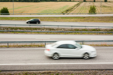 Blurred cars in motion. Asphalt roads with cars at autumn in Finland.