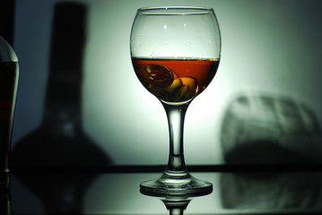 brandy in a glass on a black glass with reflection