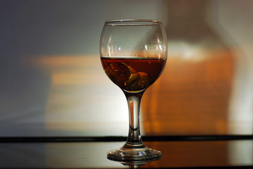brandy in a glass on a black glass with reflection