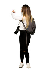 Full body of Young photographer woman pointing back with the index finger