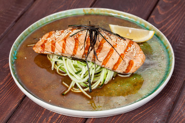  appetizing fried fish, beautifully laid out with greens and vegetables on a dish, for designer solutions in cooking