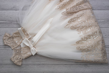 Beautiful dress with lace for small princess on wooden background.